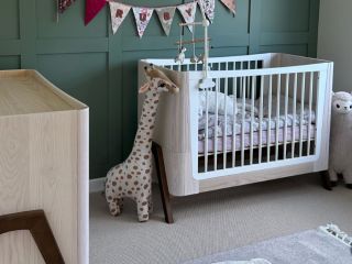 modern nursery with green panelling and a cream loop cobble carpet